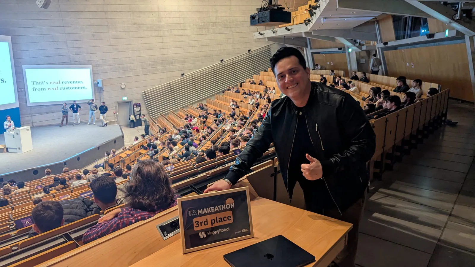Javier en el auditorio con la placa de 3er lugar sobre la mesa